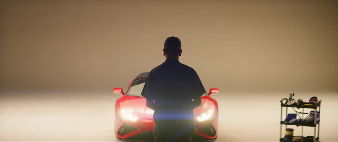 Lights flash around the car and a man walks by