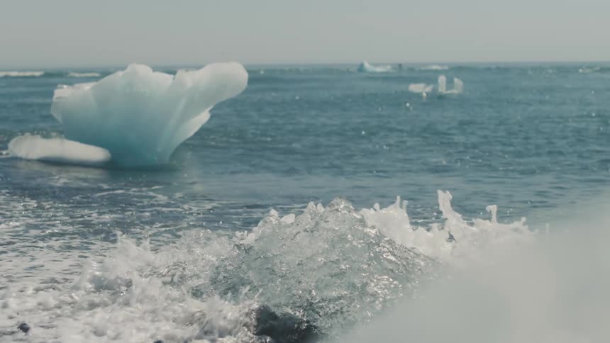 Panorama of the sea with waves on black sand and ice caps