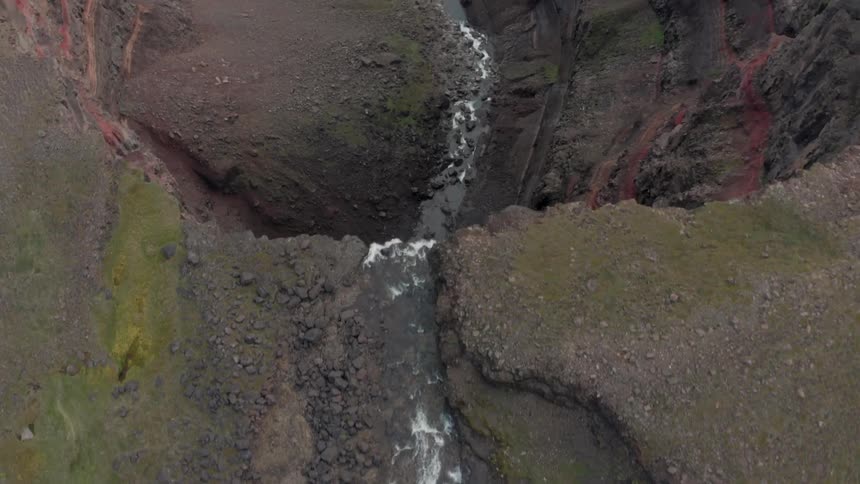 The water pours off cliff to create a waterfall