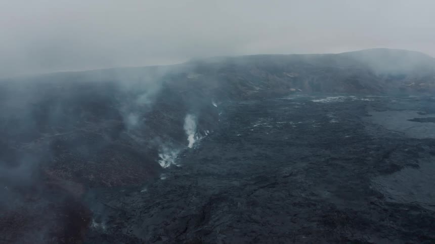 A region with black soil and lots of smoke coming out of holes
