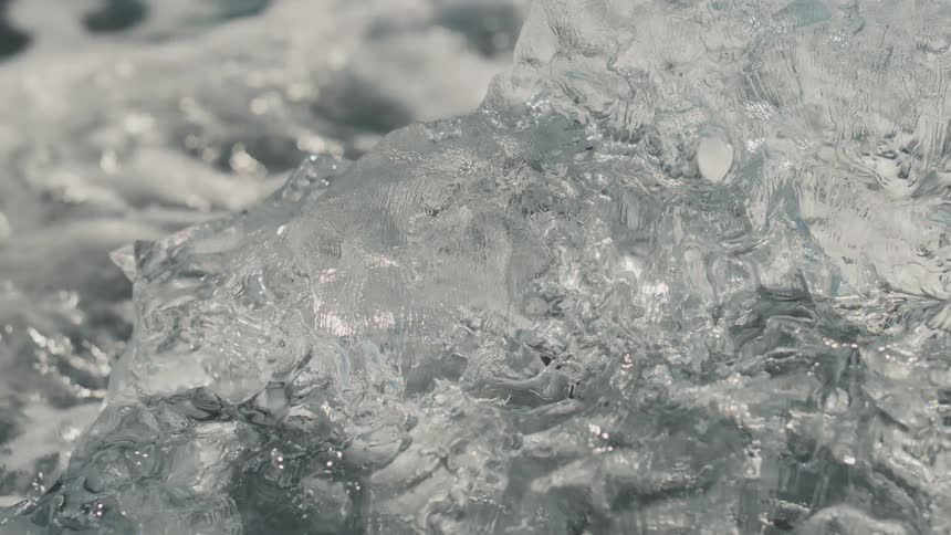 A block of ice melts as its hit by ocean waves
