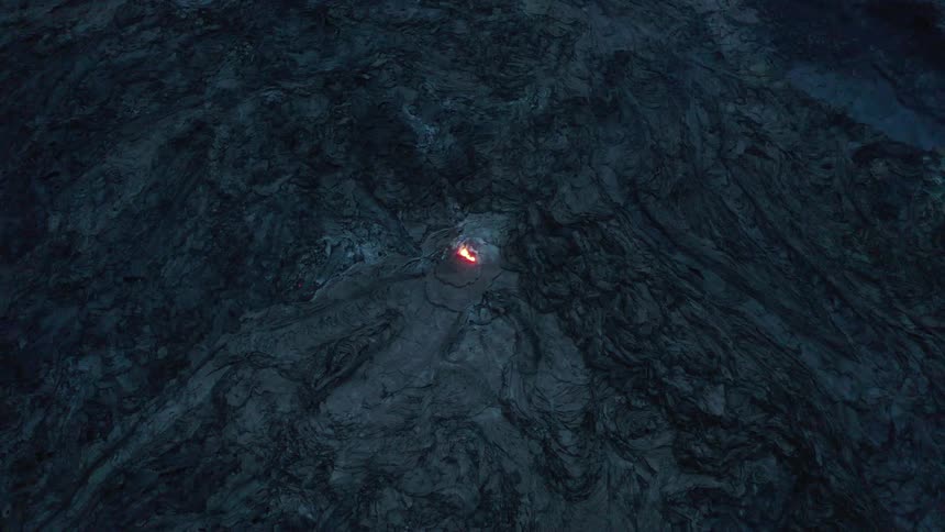 Aerial panorama of a crater with internal lava at night