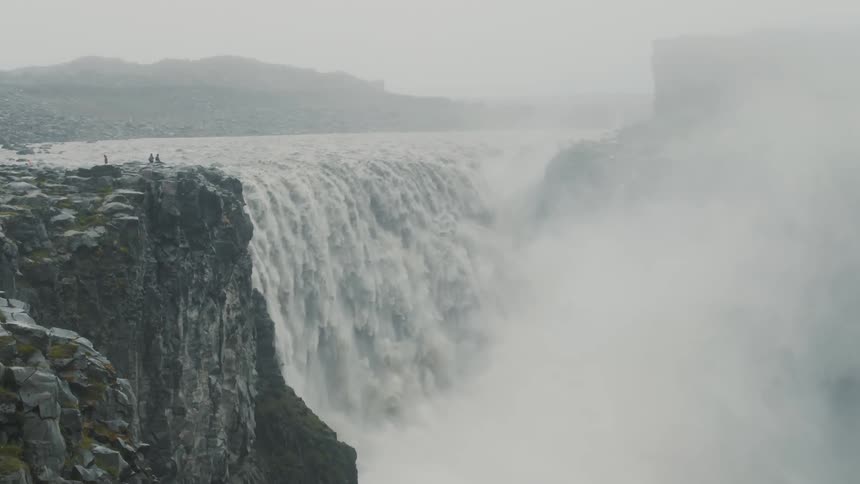 A large waterfall that makes a mist of drops below