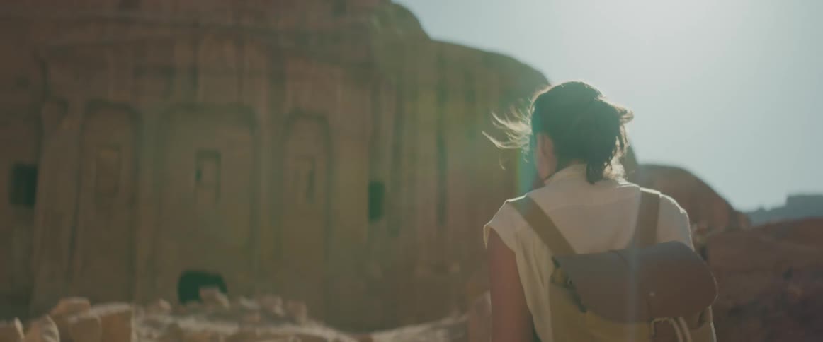 Woman walking away in the midst of an archaeological site among the ruins