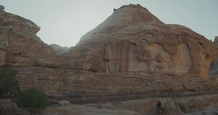 A person heading down a rocky mountain path on the back of a donkey