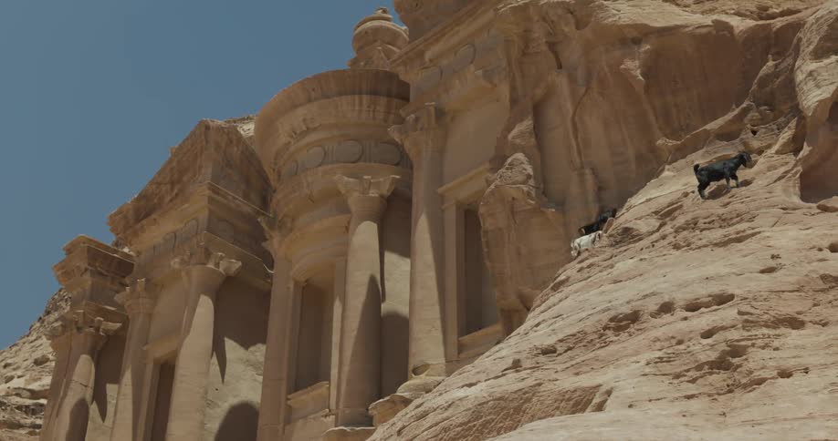 Touristic and archaeological site amidst mountains with goats climbing