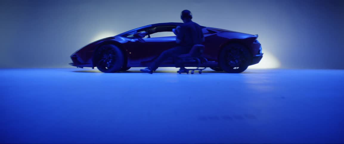 Man sitting in a chair polishing a lamborghini