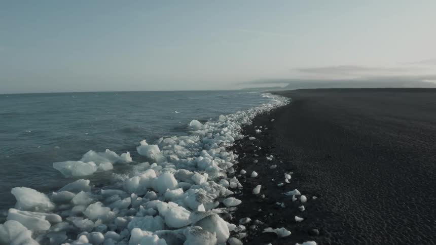 Aerial of a beach with ice caps on the coast