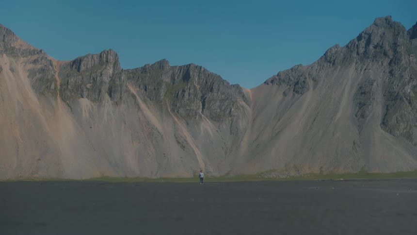 A person walking in a desert landscape with mountains