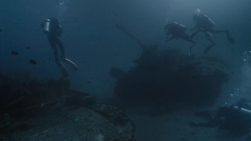 Divers examining war tanks at the bottom of the ocean