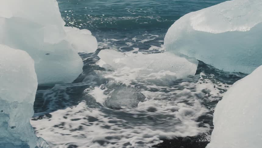 View of seawater passing beneath small icebergs