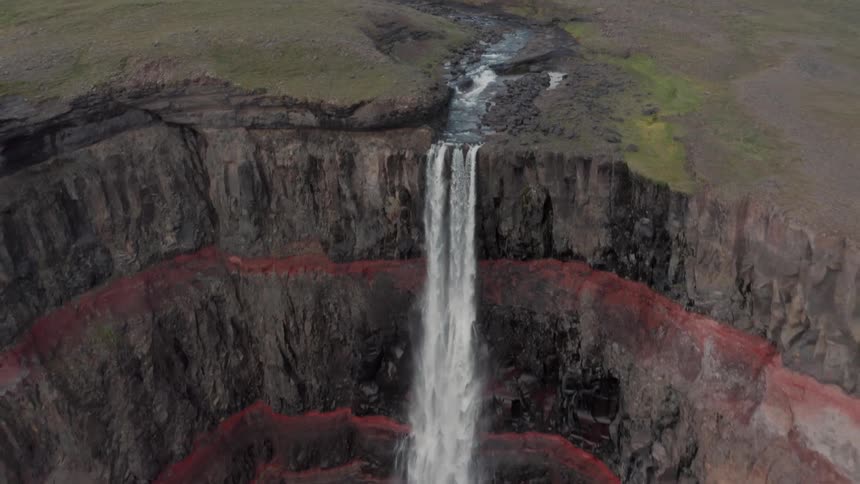 Aerial of a waterfall falling from a rocky cliff