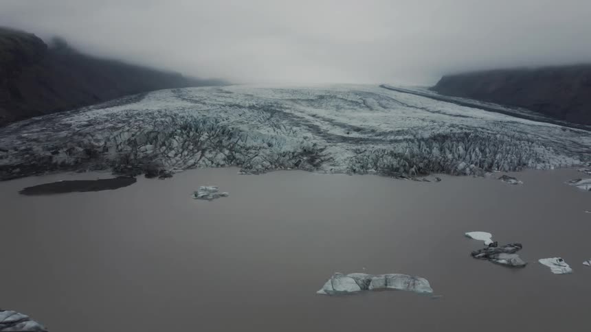 Aerial of ice caps on water during cloudy day