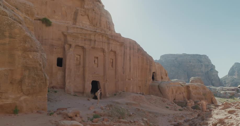 Woman amidst archaeological ruins on a day with a blue sky