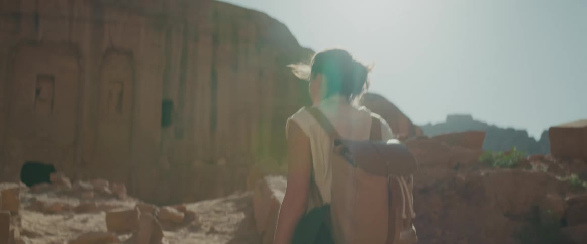 A woman walking through an archaeological site on a sunny day