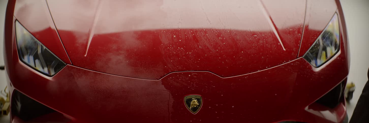 Front of a car with water dripping from the hood