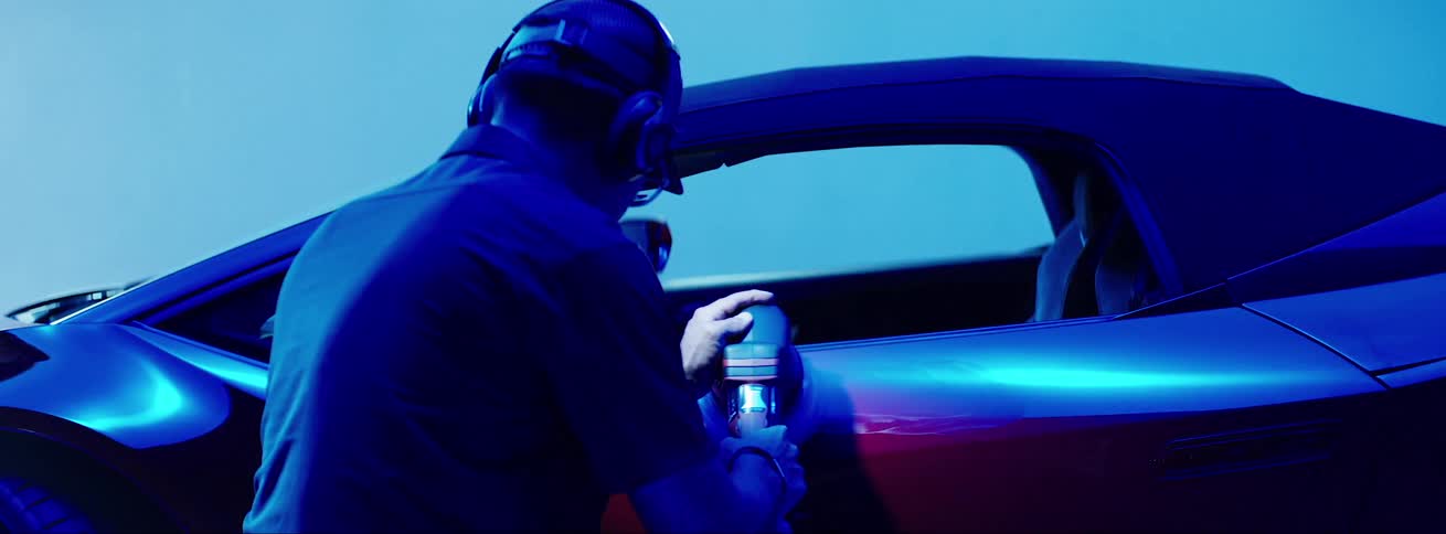 Man with a machine polishing the door of a lamborghini