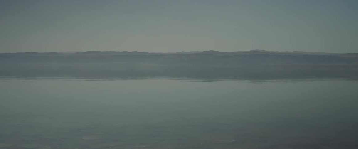 Panorama of a calm sea with a chain of mountains on the horizon