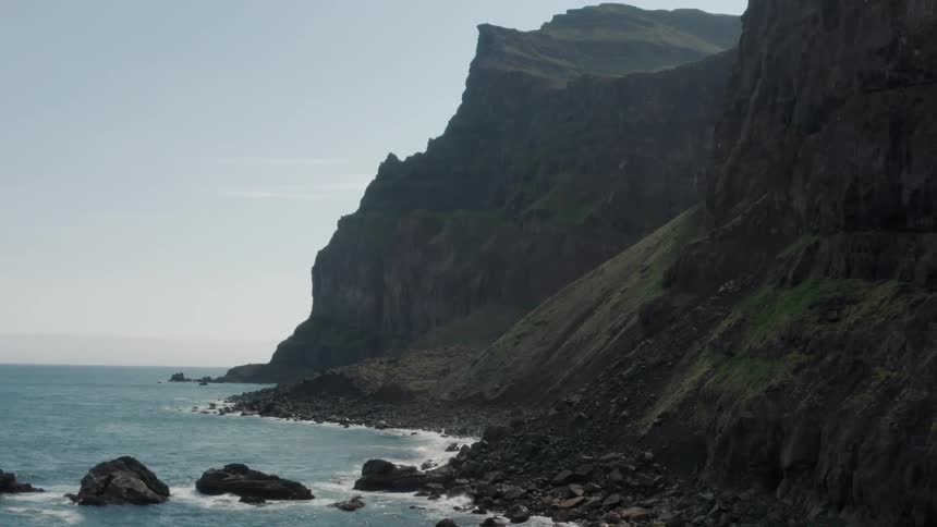 Waves splash against rocks along the coast at the foot of a promontory