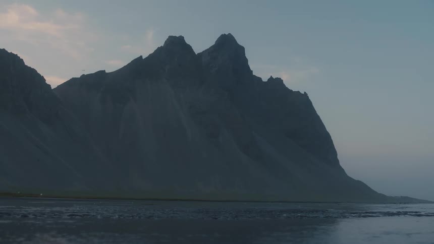 Panorama of a flowing river with a chain of mountain cliffs in the morning