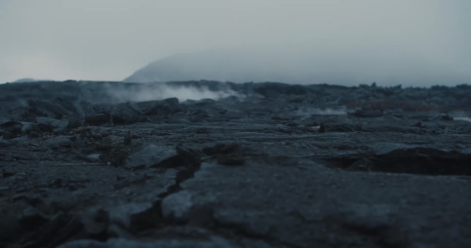 A volcanic mountain with smokes coming out from the ground