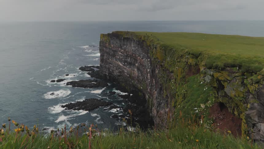 Sea coast with rocky cliffs during cloudy day