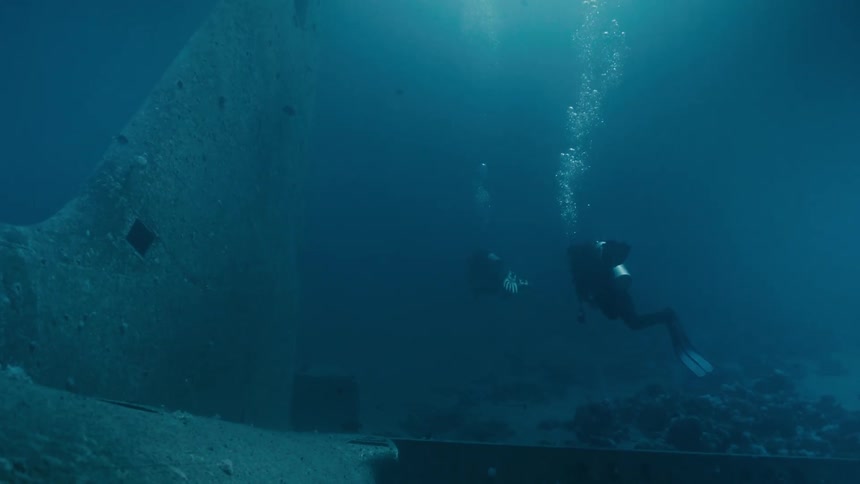 Two divers exploring the wreck of a sunken airplane