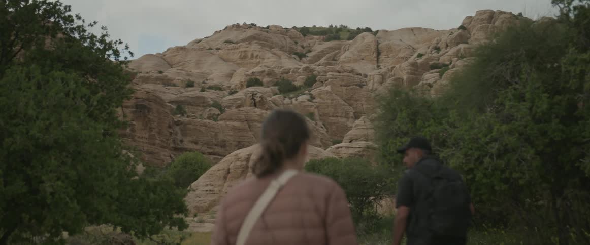 Woman and man walking in nature in the valleys on a cloudy day