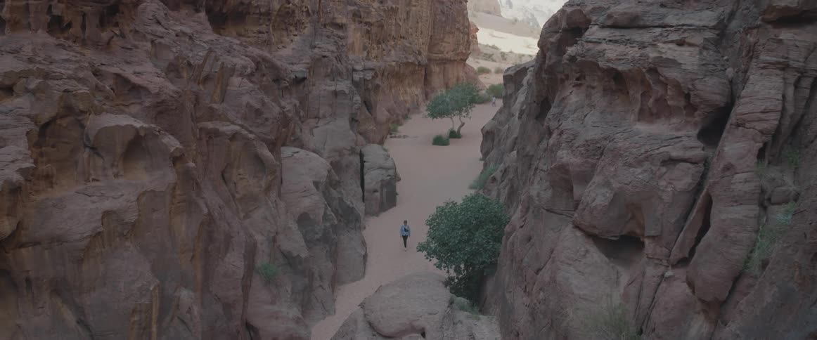 Aerial panorama of a person walking in the midst of a valley