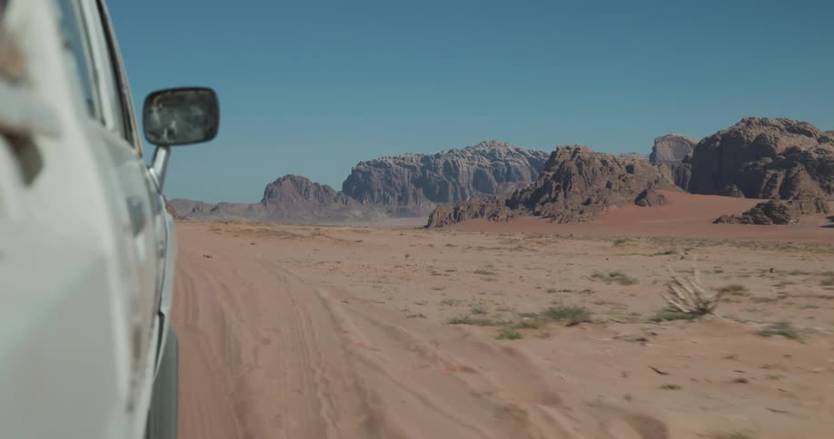A car driving behind another car in the desert