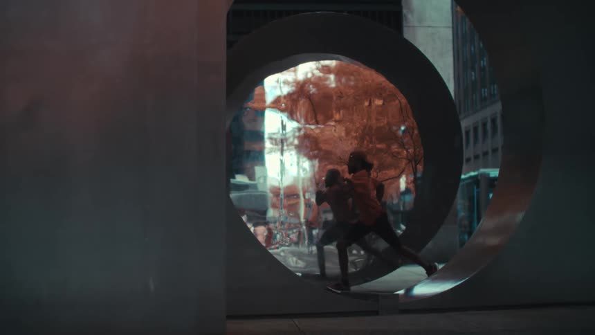 A man is running behind a building with spiral architecture