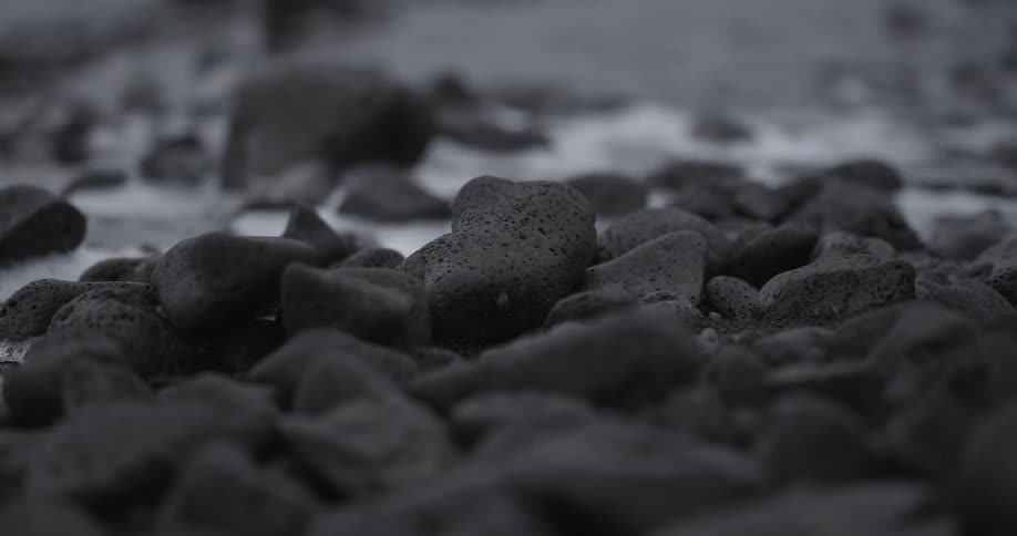 Water flows over rocks on a beach