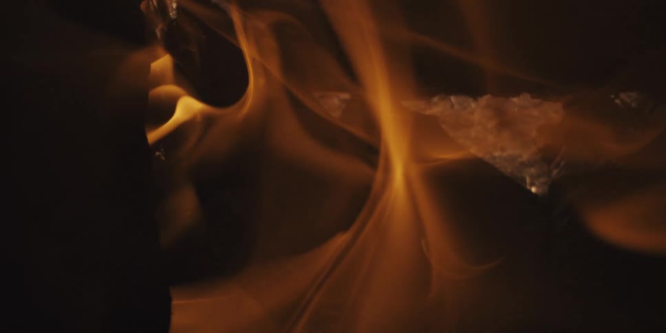Extreme close up of natural firewood catching and expelling fire in slow motion