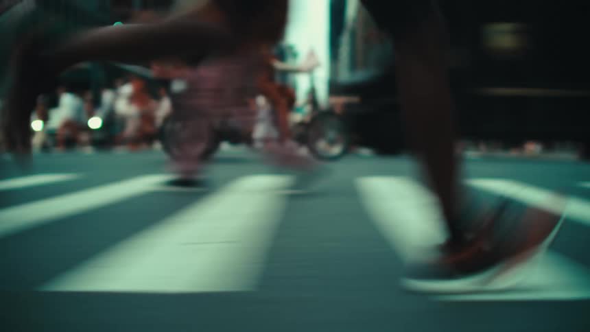 A person running in the crosswalk of a busy avenue