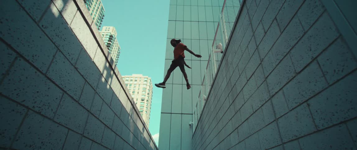 A boy practicing parkour on the urban city walls