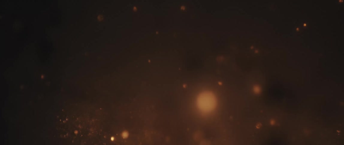 A small bright explosion and several sparks falling on a black background