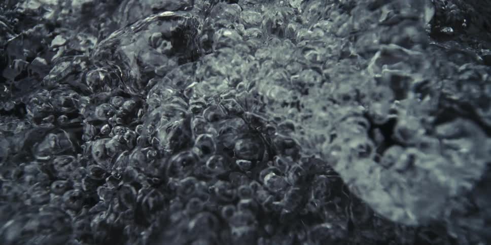 Extreme closeup of water with bubbles in slow motion