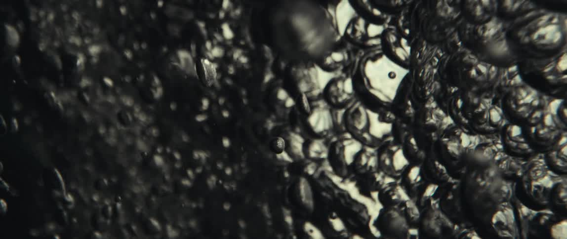 Closeup reveals water bubbles rising floating upward