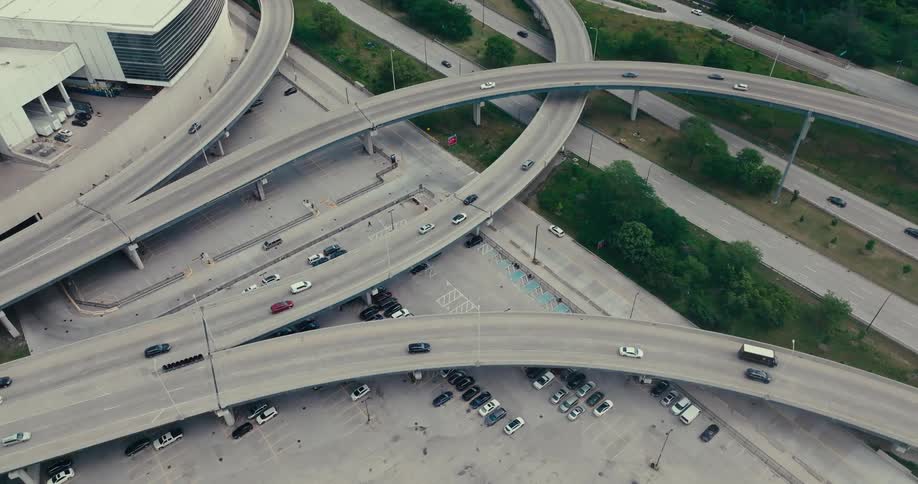 An aerial view of various roads of tarmac with some cars driving on them