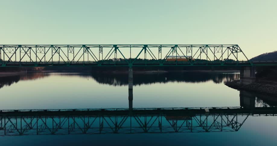 A school bus passes over a bridge over the river
