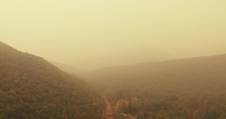 Panorama of a mountain range with forests and fog in the morning