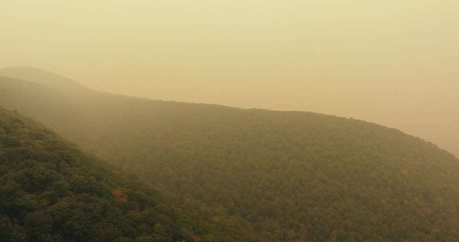 Panorama of a mountain range with forests and fog in the morning