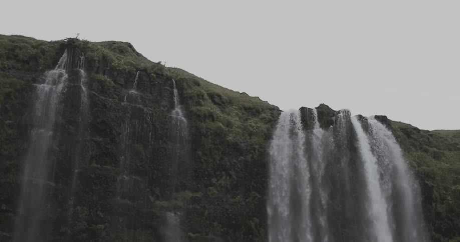 Water flows over the cliffside falling to the bottom