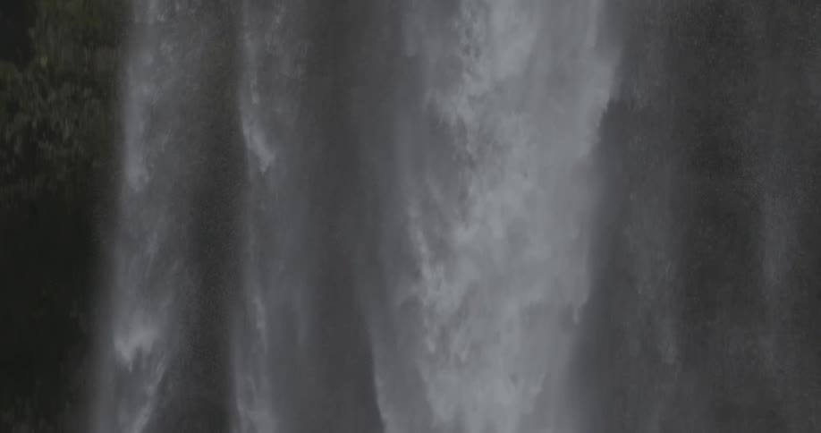 The tall waterfall gives off huge sprays of water