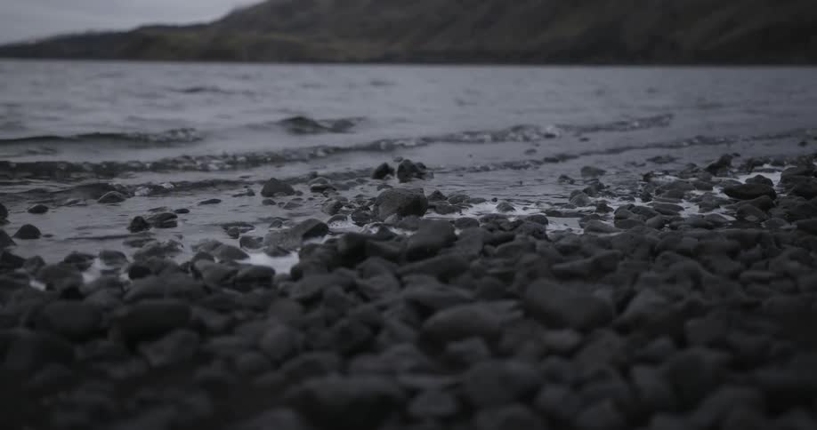 Waves slowly hit the rocks on the shore