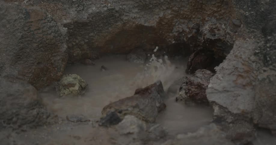 Water bubbles and steams between rocks