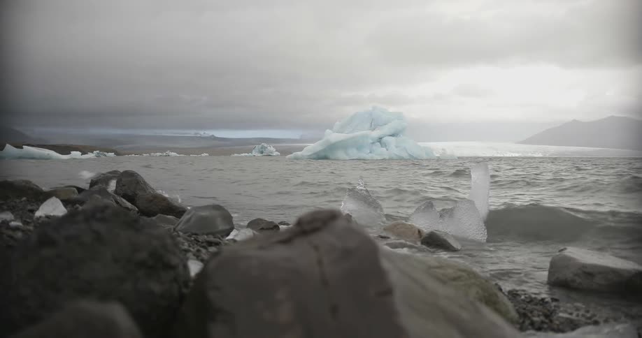 Icy ocean water rolling up onto rocky beach