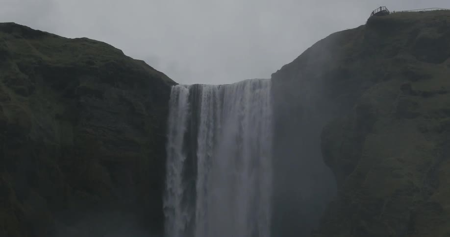 Water flowing over a very high waterfall on a cloudy day