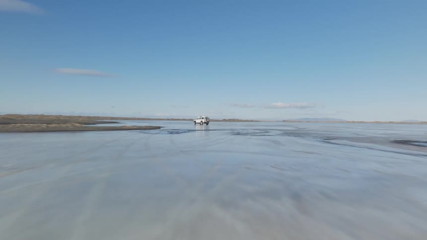 A car speeding across an icy plain during the day