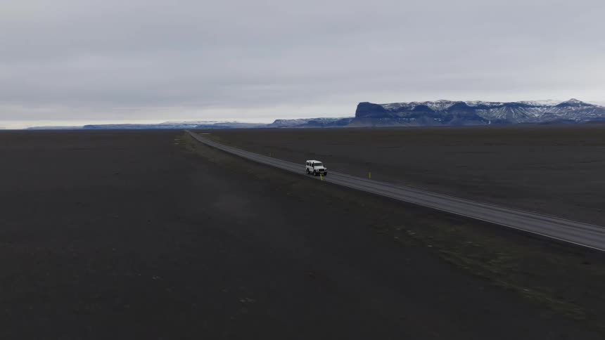 A car driving along a deserted road in the wild nature